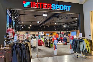 The entrance to Intersport Leira, racks with outdoor jackets and the logo over the entrance.