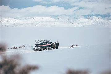 Beltebil på avstand i vinterlandskap i høyfjellet