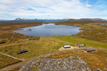 View from Valtjernknatten over Lake Valtjern and the Stølsvidda plateau. The cycling tour "Stølsvidda circuit" leads along the road that can be seen b