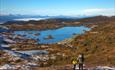 A father with a child on a hike above the tree line with far view to high mountains.