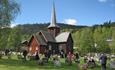 Trekirke og kirkegård med folk som er på vei inn i kirka.