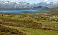 Støler med beiter, vann og høye fjell i bakgrunnen