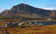 Bitihorn shows its rough side with its steep east face to the photogapher. In the foreground some small lakes and lichen-covered rocks.