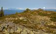 Tveitastølsfjellet is a high point on the ridge towards Jutulen. In the backgroudn a snow-covered mountain chain.