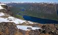 Formidabel utsikt fra Skjøld til flere vann i dalen nedenfor og høye fjell i bakgrunnen.