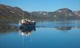 The historical boat M/B Bitihorn on Lake Bygdin's calm waters.