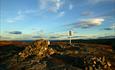 A small summit cairn on a high point in the mountains in beaitful evening light in autumn.