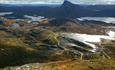 Breathtaking view from Synshorn towards Bygdin, Bitihorn and many small lakes. The National Tourist Route Valdresflye winds through the rugged mountai