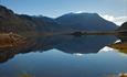 A mountain mirrors itself in a lake.