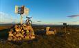 Summit cairn at Gribbe (1057 m.a.s.l.) and a bicycle in the soft light of the evening sun.