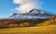 Ein strahlend schöner Herbsttag in Vang mit bunten Farben und dem Berg Grindane, der vom ersten Neuschnee bedeckt ist. Die Fahhradtour "Familienrunde in Vang" verläuft im unteren Berghang.