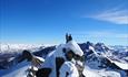 To personer på fjelltopp blant ville fjell i Jotunheimen