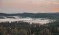 Vid utsikt over skogkledde fjell og koller.