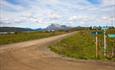 Langestølen farm area with the farm road leading straight for a long way towards the mountains in the background.