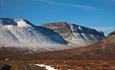 Den første nysnøen ligger på fjelltoppene som reiser seg bratt på andre siden av Smådalen.