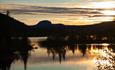 Lake Steinsetfjorden seen from its southern end close to the outflux in the soft light of the setting sun. In the background, the characteristic Runde