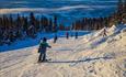 Skikjørere i en av nedfartene med superutsikt mot fjellene i Valdres Alpinsenter i Aurdal.