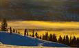 Snow boarders against the setting winter sun in great surroundings at Valdres Alpinsenter in Aurdal.