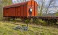 At the old Bjørgo station there are still to grass overgrown train tracks and a red train, consisting of a locomotive and a couple of wagons. A cyclis