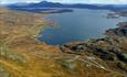 Utsikt fra fjellet Synshorn over Vinstre med Jotunheimenvegen som snor seg langs bredden. Bildet virker å være tatt fra luften.