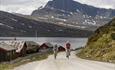 Cycling along Jotunheimvegen, a part of the Mjølkevegen Cycling Route, with the mountain of Bitihorn in the background.