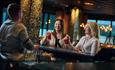 Two ladies enjoy a drink at a bar counter
