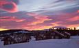 Kleine Holzhütten im Winter im Sonnenuntergang