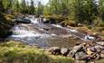 Bach mit Stromschnellen und Vertiefung zum Baden