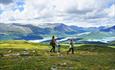 Familie auf Wanderung in offenem Fjellgelände mit Seen und Bergen