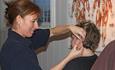 A therapist is giving acupuncture to a patient.