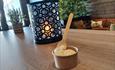 Candle in a candle holder and an ice cream cup on a restaurant table
