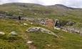 Scenery along the trail from Storekrak to Vassfarkoia with open fjell and the tiny hut Harehopp.