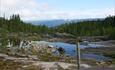 Am Damm über den Ausfluss des Bløytjern mit Blick flussabwärts antlang der Åbjøra. Der Wasserstand ist niedrig, und Steine liegen frei.