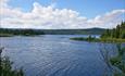 View over Lake Ølsjøen. Blue skies and some whiote clouds as well as small ripples on the water.