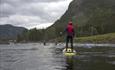 Stand-up-boarder auf einem ruhigen Fluss