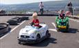 Children in small electric vehicles on an asphalt track at Beitostølen