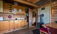Hölzernes Interieur einer Berghütte mit Küchenzeile und Holzofen
