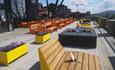 The sun deck of Lodge 900 with modern, colourful tables and benches made of steel and wood.