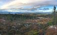 View from Vardafjell over mountain forests towards mountain on the very far horizon.