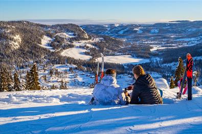 Zwei Skifahrerinnen genießen eine Pause in der Piste mit einer großartigen Aussicht.
