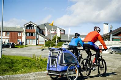 Syklister med sykkeltilhenger utenfor Oset Fjellhotell