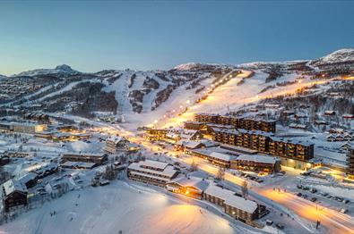 Dronefoto Beitostølen vinterkveld med Bergo i forkant, alpinsenteret bak