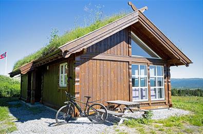 Hütte mit Grasdack und einem Fahrrad vor der Tür