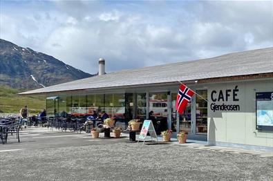 Cafe Gjendeosen entrance with chairs and small tables on the side.