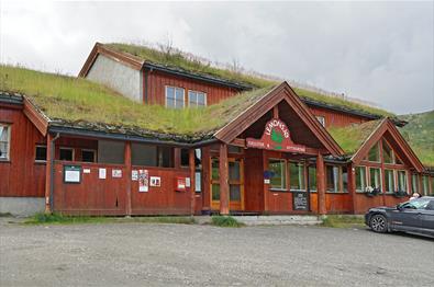 Traditionelle norwegische Mountain Lodge mit Holzpanel und Grasdach.