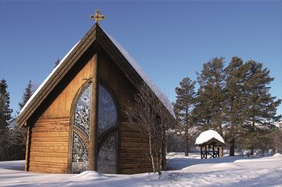 Det lille, fine Lyskapellet på Beitostølen utenfra på vinteren med snø på bakken.