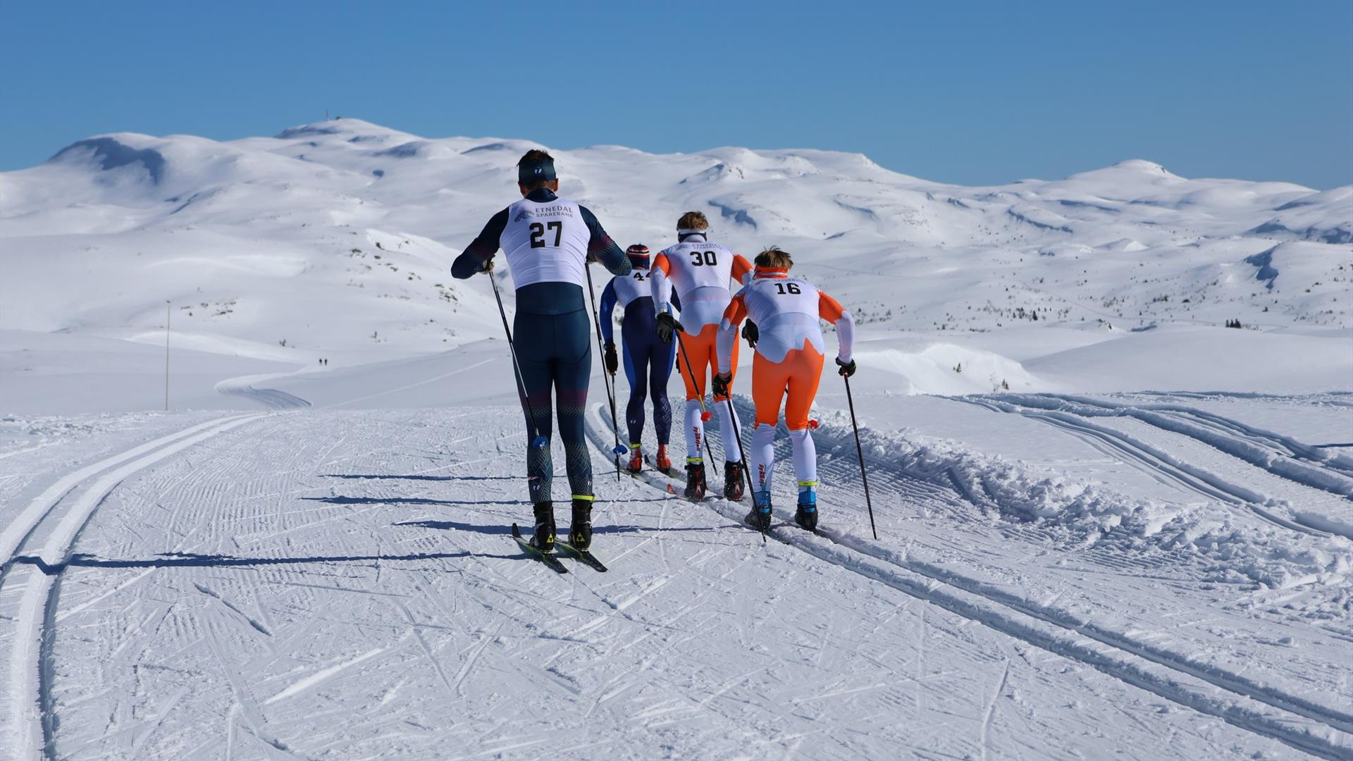 Skiløpere under Jomfruslettfjellet rundt en flott solskinnsdag.
