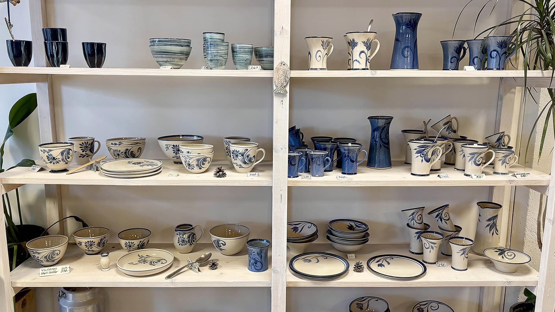 hylle med håndlaget keramikk i beige- og blåtoner