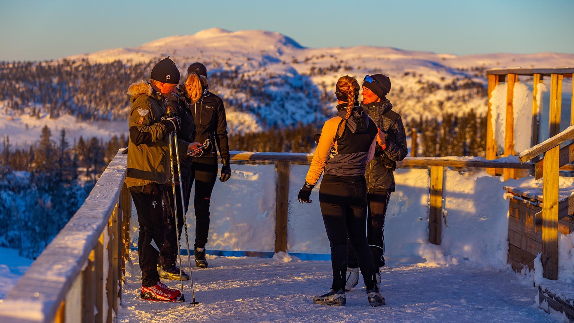 Folk tar pause fra skituren med utsikt over vinterfjell