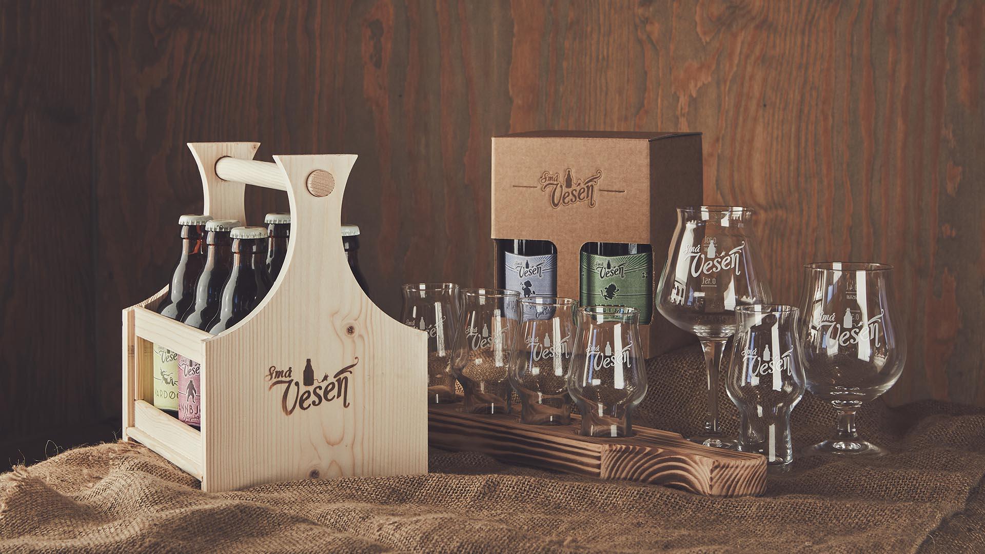 Small wooden crate of beer, cutting board with small beer glasses, larger beer glasses and a nice carton with 4 beers, all locally produced beers from Valdres.